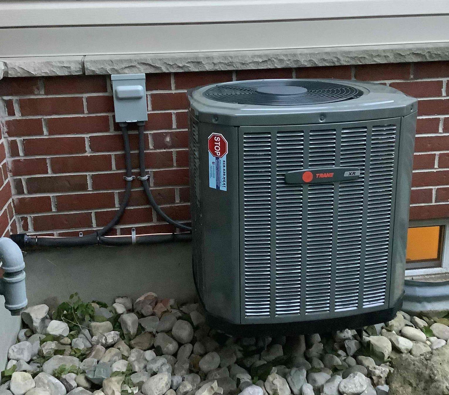 Trane AC installation at side of home in the summer.