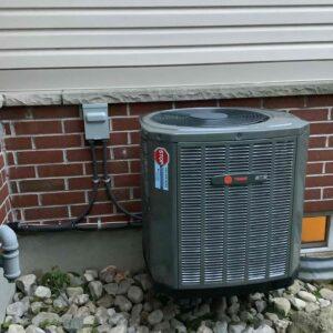 Trane AC installation at side of home in the summer.