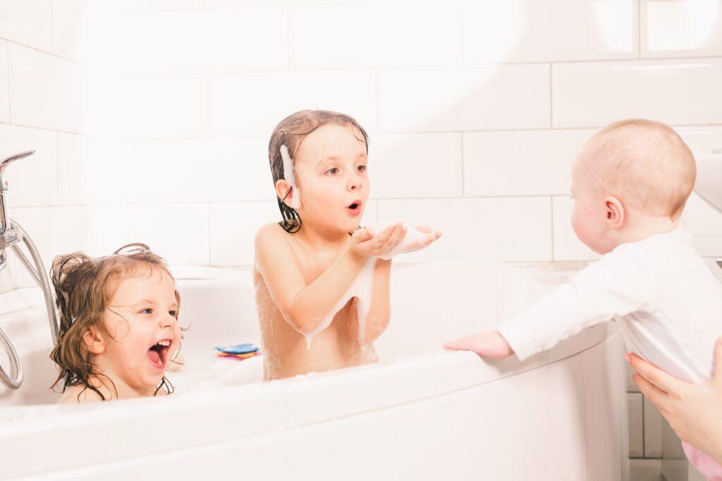 tank vs tankelss water heater. Younge children in bathtub.