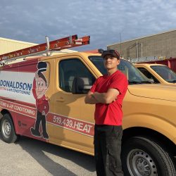 Donaldson technician working on HVAC equipment inside a home.